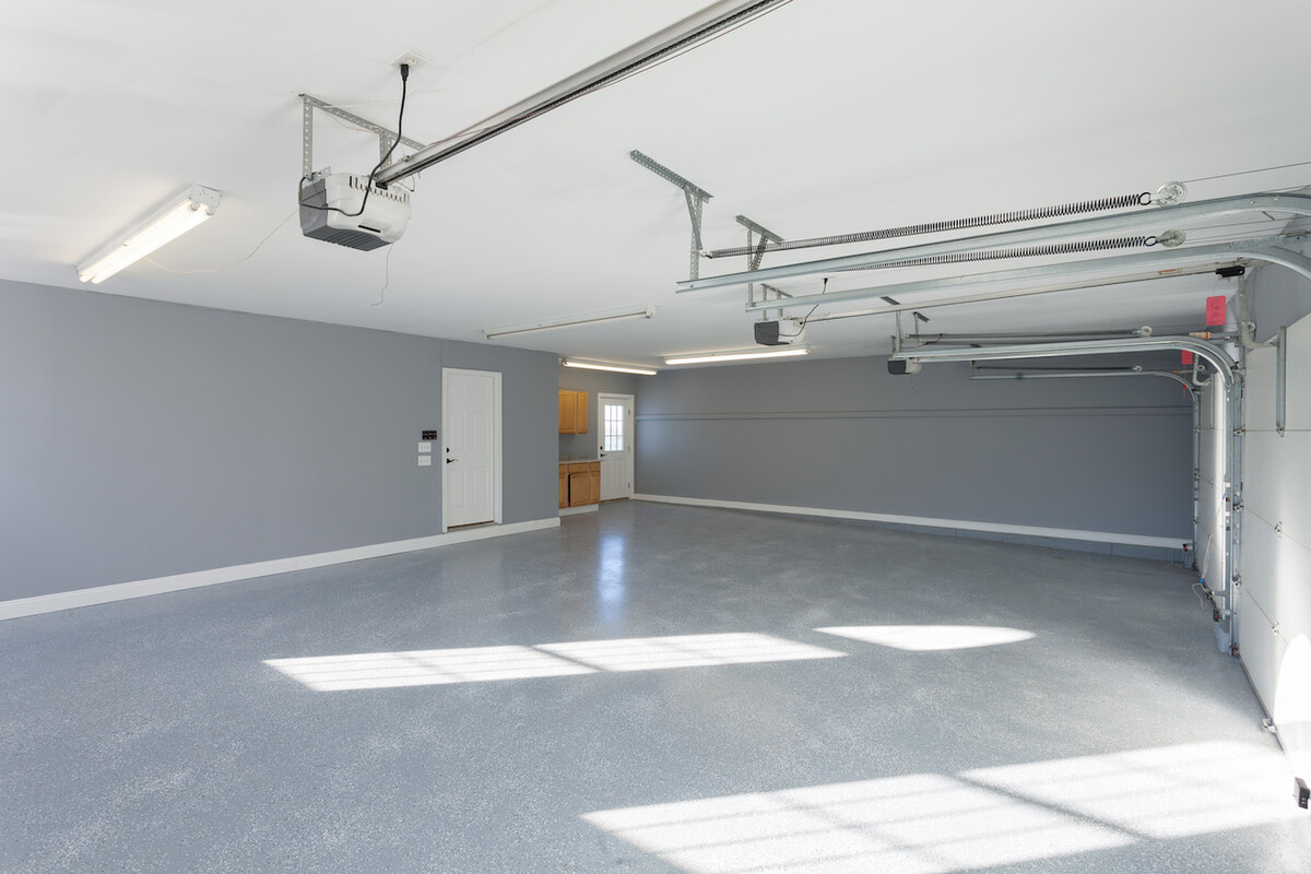 Beautiful brand new three car garage interior with finished floors and work space.