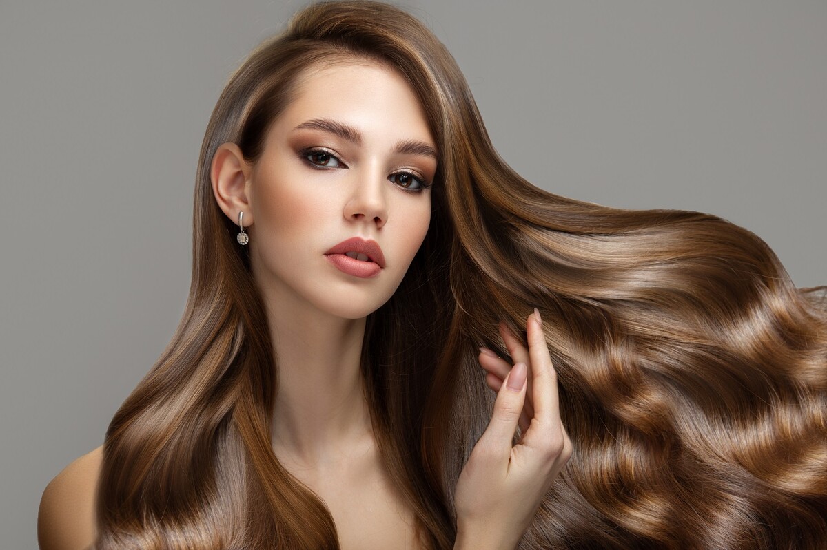 Portrait of a beautiful brunette woman with long wavy hair. Copycpase